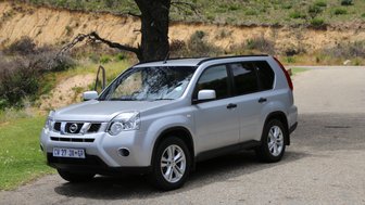 Fahrzeug im Chapman's Peak Drive mit Blick auf die beeindruckende Naturkulisse – Garden Route Reise mit Kindern