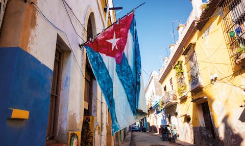 Eine große kubanische Flagge weht an einem Gebäude in einer Straße von Havanna