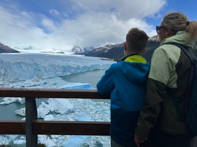 Ein Junge und eine Frau stehen an einem Geländer und betrachten den beeindruckenden Perito-Moreno-Gletscher in Argentinien.