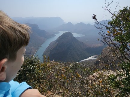 Ein Kind steht am Rand des Blyde River Canyons und blickt fasziniert auf die Landschaft – Südafrika mit Kindern