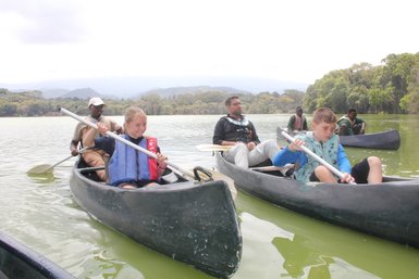 Familiengruppe paddelt bei einer Kanutour auf dem Duluti-See – Tansania Reise mit Kindern