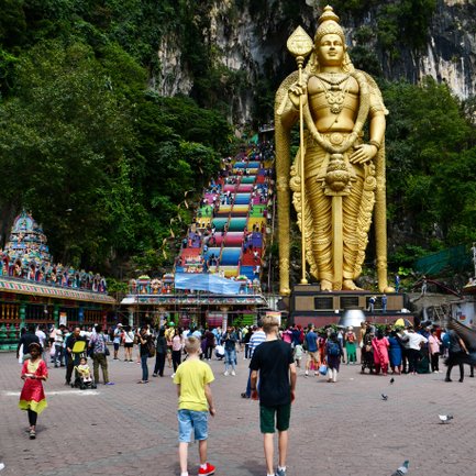 Eine goldene Statue wacht über den Eingang der Batu-Höhlen – Malaysia & Borneo mit Kindern