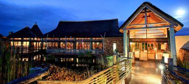 Ein stilvolles Lodge-Gebäude mit Holzverkleidung und einem einladenden Eingangsbereich, umgeben von sanften Lichtverhältnissen.