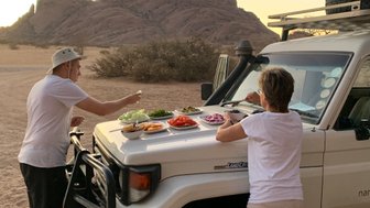 Eine Mutter isst mit ihrem Sohn auf der Motorhaube eines Jeeps - Namibia mit Jugendlichen