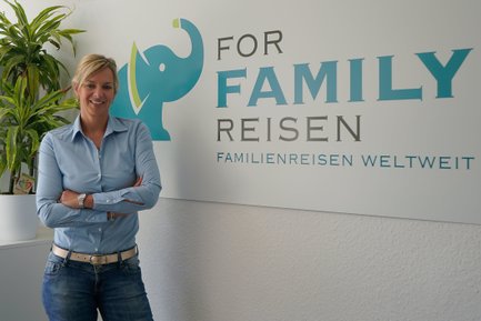 Geschäftsführerin Nadja Albrecht neben For Family Reisen Schild