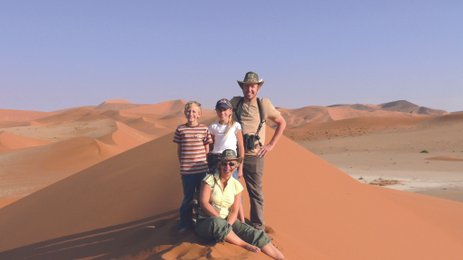 Eine Familie steht auf einer Sanddüne - Namibia mit Kindern