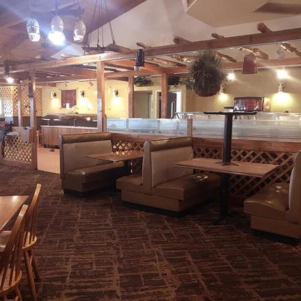 Ein gemütliches Restaurant mit Holzmöbeln und bequemen Sitzecken, ideal für gesellige Zusammenkünfte.