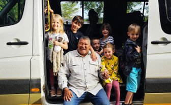 Reiseleiter sitzt mit Kindern im Bus - Garden Route mit Kindern