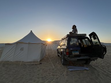 Junge auf einem Jeep in der Weißen Wüste mit Zelten im Hintergrund – Ägypten Reise mit Kindern