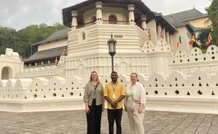 Reiseleiter und Frauen posieren gemeinsam vor dem Zahntempel in Kandy – Sri Lanka Familienreise