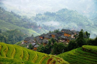 Panorama der Reisterrassen von Longsheng mit Blick auf traditionelle Holzhäuser – China Familienreise