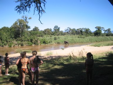 Kinder und Teenager beobachten einen Elefanten der im Wasser badet – Südafrika Reise mit Kindern
