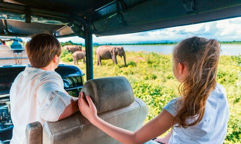 Eine Familie fährt im offenen Jeep durch den Udawalawe Nationalpark auf der Suche nach wilden Tieren – Sri Lanka mit Kindern