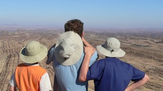 Eine Familie blickt gespannt in die weite Ferne - Namibia Rundreise mit Kindern