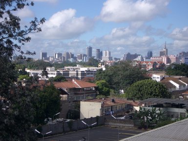 Eine weite Aussicht auf die Skyline von Nairobi, mit modernen Gebäuden und üppigem Grün im Vordergrund.