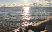 Ein entspannter Moment am Wasser, während die Sonne über dem Horizont aufgeht und die Wellen sanft plätschern.