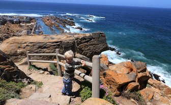 Baby schaut von oben auf das Meer in Mossel Bay entlang der Garden Route – Garden Route Familienreise