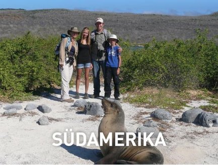 Eine Gruppe von vier Personen steht auf einem sandigen Weg, umgeben von grüner Vegetation und einem ruhigen Meer im Hintergrund.