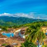 Blick auf die farbenfrohen Häuser von Trinidad, umgeben von üppigen Bergen und einem strahlend blauen Himmel.