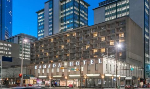 Das Ramada Hotel in Calgary zeigt eine moderne Architektur mit beleuchteten Fenstern und einem klaren Abendhimmel.