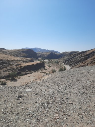 Eine staubige unasphaltierte Straße - Namibia mit Jugendlichen