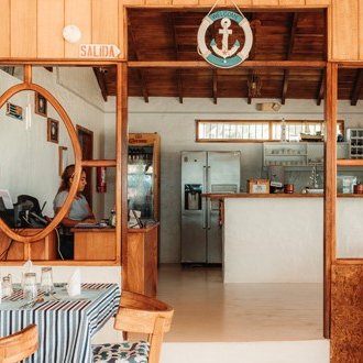 Ein einladendes Restaurant mit Holzdekor, das eine gemütliche Atmosphäre und eine offene Küche bietet.