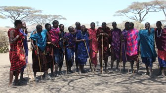 Massai-Männer in farbenfroher traditioneller Kleidung im Dorf – Tansania Reise mit Kindern