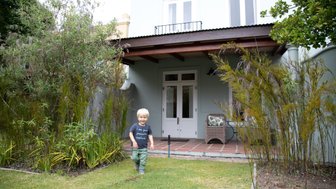 Kind genießt den Garten des The President Hotel Bungalow in Kapstadt – Garden Route mit Kindern