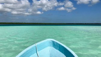 Kleines Boot auf dem türkisgrünen Wasser der Bacalar-Lagune – Mexiko mit Kindern