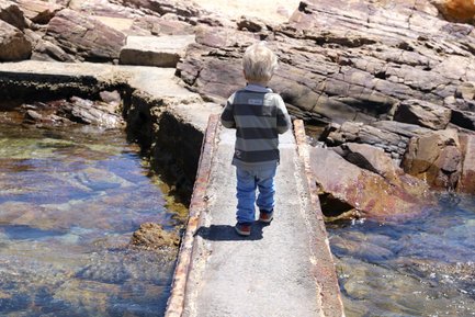 Kleines Kind balanciert über eine Brücke über Wasser in Mossel Bay – Garden Route Reise mit Kindern
