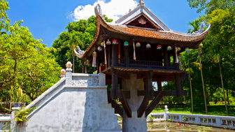 Ein traditionelles vietnamesisches Gebäude mit einem geschwungenen Dach steht über einem Teich voller Seerosen.