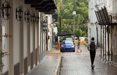 Eine schmale, gepflasterte Straße in Casco Viejo, Panama, umgeben von historischen Gebäuden und begrünten Balkonen.