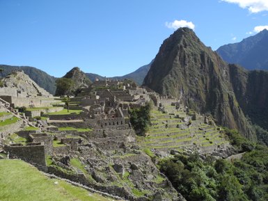 Die beeindruckenden Ruinen von Machu Picchu liegen majestätisch inmitten der Anden, umgeben von üppiger Natur und hohen Bergen.