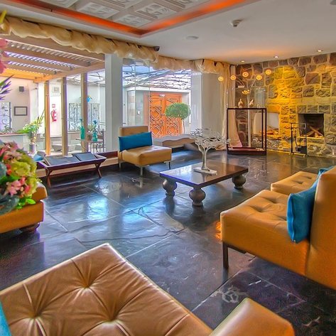 Der elegante Empfangsbereich des Ikala Quito Hotels zeigt moderne Möbel und eine einladende Atmosphäre mit Pflanzen.