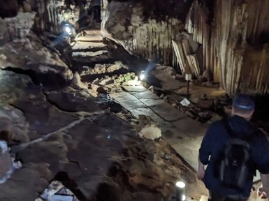 Entdecker erkundet geheimnisvolle Tropfsteinhöhle mit Laterne – Thailand Familienreise