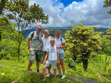 Familie lächelt und posiert im grünen Dschungel – Costa Rica mit Kindern