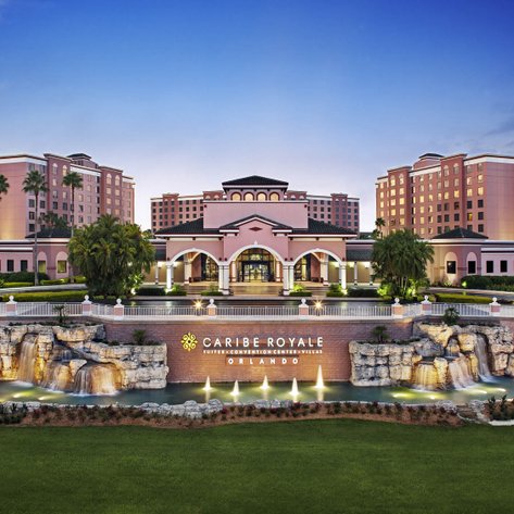 Das Caribe Royale Resort in Orlando zeigt eine eindrucksvolle architektonische Fassade, umgeben von üppigem Grün und Wasserfällen.