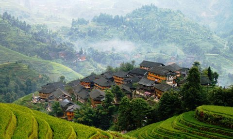 Panorama der Reisterrassen von Longsheng mit Blick auf traditionelle Holzhäuser – China Familienreise