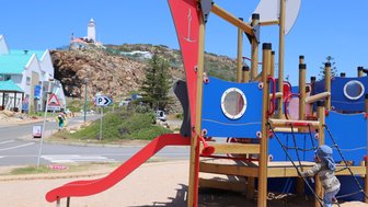 Baby spielt auf einem Spielplatz in Mossel Bay an der Küste der Garden Route – Garden Route Familienreise
