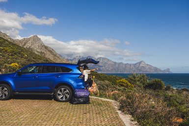 Mutter sitzt im Kofferraum vom Auto und genießt Ausblick – Südafrika Reise mit Kindern