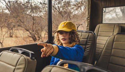 Junge sitzt im Jeep während einer Safari in der Kubu Safari Lodge – Südafrika mit Kindern