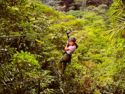 Ein mutiges Mädchen gleitet an einer Zipline durch die Baumwipfel des Regenwaldes – Costa Rica Familienreise