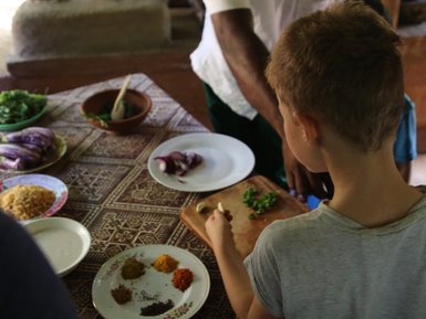 Kind bei der Zubereitung eines Gerichts mit Einheimischer in den Tamarind Gardens – Sri Lanka mit Kindern