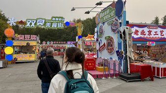 Eine belebte Essensstraße mit bunten Ständen und Menschen, die die Atmosphäre eines Marktes genießen.