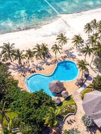 Ein atemberaubender Blick auf den Pool des Karafuu Beach Resorts, umgeben von Palmen und dem glitzernden Ozean.