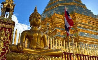 Tempel Wat Phra That Doi Suthep mit goldener Buddha Statue im Vordergrund in Chiang Mai - Thailand Reise mit Kindern