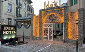 Der Eingangsbereich des Ideal Hotels zeigt eine kunstvoll gestaltete Fassade mit warmem Licht und einem eleganten Tor.