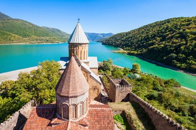 Die beeindruckende Ananuri-Festung thront majestätisch über dem glitzernden blauen Wasser des Stausees.