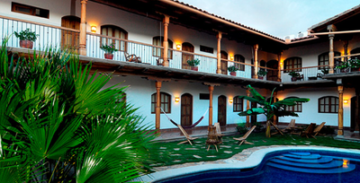 Ein einladender Innenhof mit einem Pool, umgeben von Pflanzen und Holzveranden, die eine entspannte Atmosphäre schaffen.