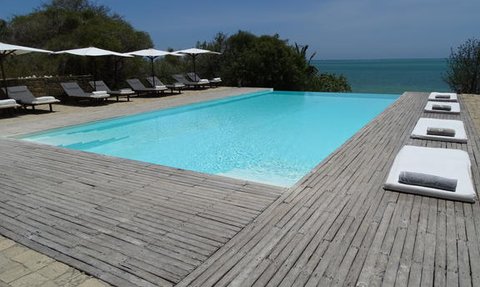 Ein einladender Pool mit klarem, blauem Wasser, umgeben von Liegen und Sonnenschirmen, bietet einen perfekten Entspannungsort.